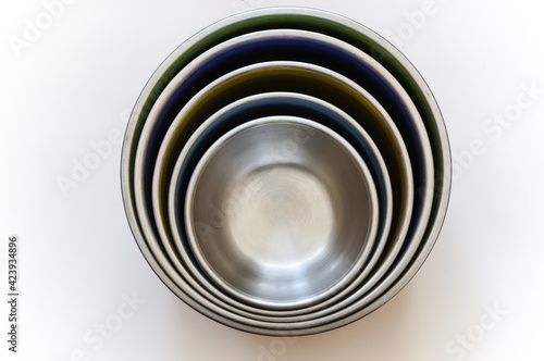 Empty metal bowls nested inside each other on a white background