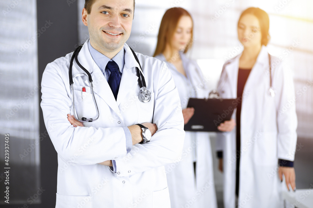 Professional middle aged doctor with a stethoscope and crossed arms at work in a sunny clinic. Perfect medical service in a hospital. Medicine and healthcare concept Professional middle aged doctor with a stethoscope and crossed arms at work in a sunny clinic. Perfect medical service in a hospital. Medicine and healthcare concept