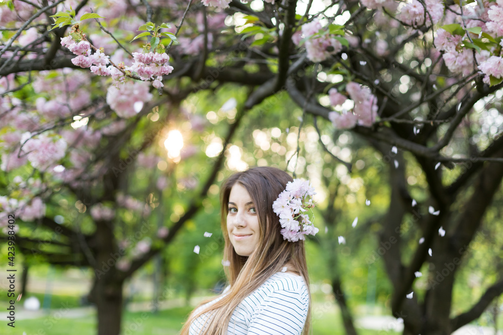 girl near blooming sakura. Spring is now. Cherry blossoms. Sakura at dusk. portrait at sunset girl near blooming sakura. Spring is now. Cherry blossoms. Sakura at dusk. portrait at sunset