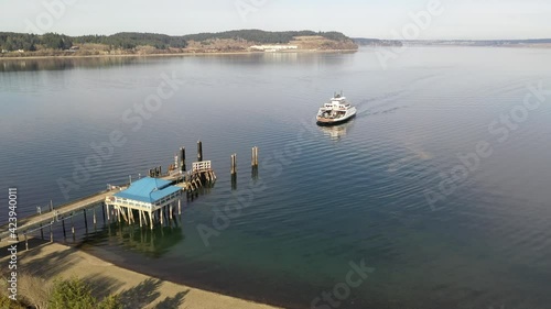 Cinematic drone aerial footage of the arriving ferry at the ferry terminal with cars on Anderson Island, Puget Sound near Mc Neil island, Steilacoom, Tacoma, Washington photo