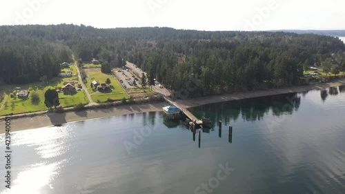 Cinematic drone aerial footage of the ferry at the ferry terminal with cars loading and unloading on Anderson Island, Puget Sound near Steilacoom, Tacoma, Washington photo