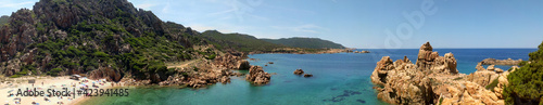 Panoramic image of Li Cossi beach, hidden between some cliffs in Sardinia. Beach only accessible on foot, with turquoise water and unspoiled natural surroundings.