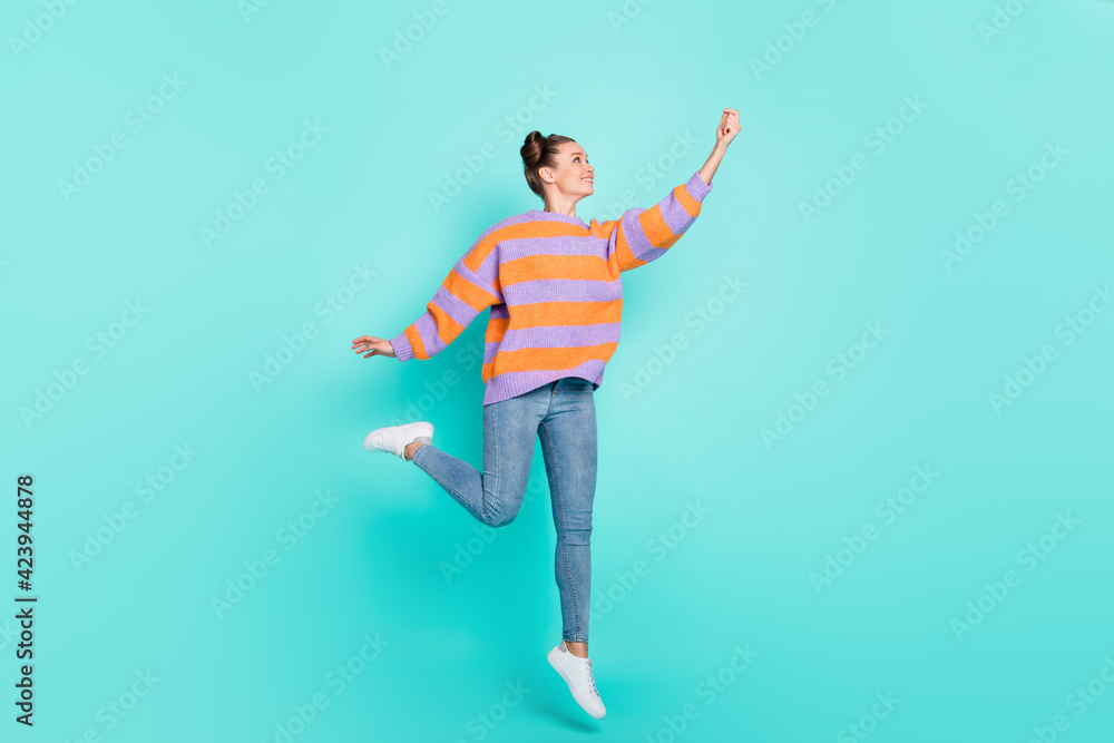 Full size profile photo of pretty girl jump look raise arm empty space imagine umbrella isolated on blue color background