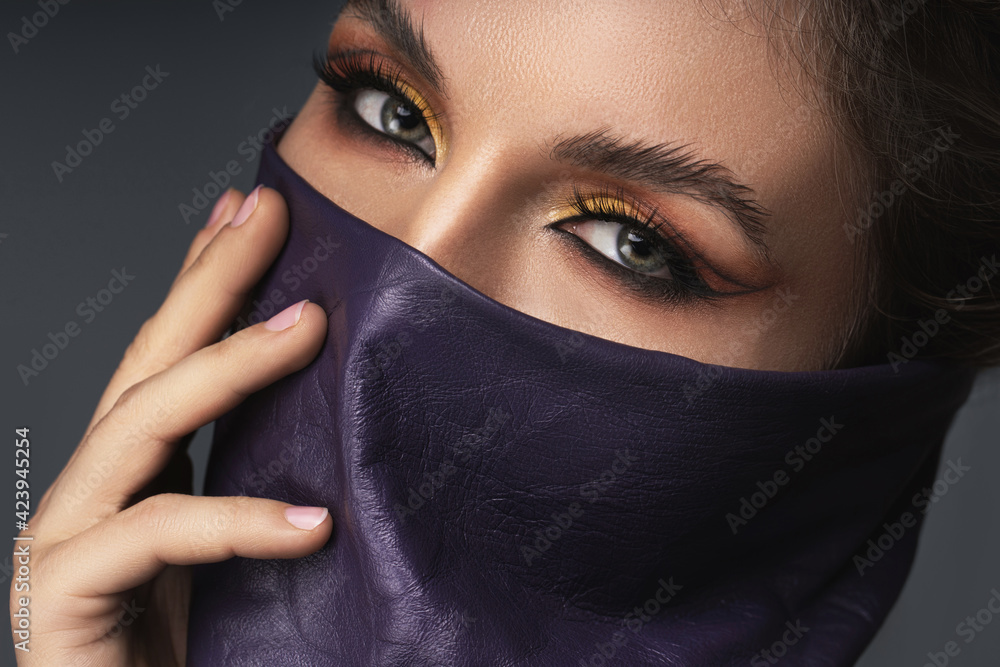 Naklejka premium Portrait of stylish woman wearing leather neck gaiter instead of prevention mask.
