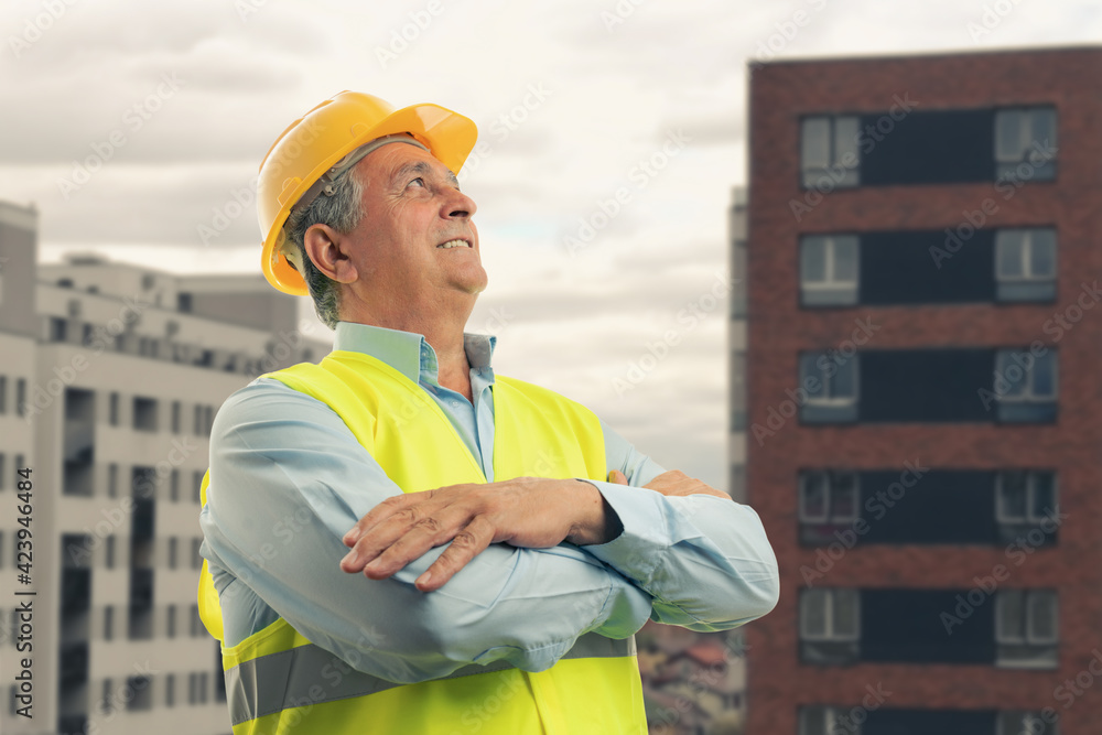 Portrait of constructor with arms crossed building background Portrait of constructor with arms crossed building background