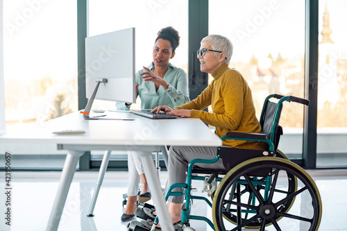 Картината върху платно Senior business woman in wheelchair working in office