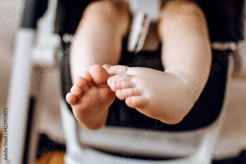 Close-up of little baby feet on highchair