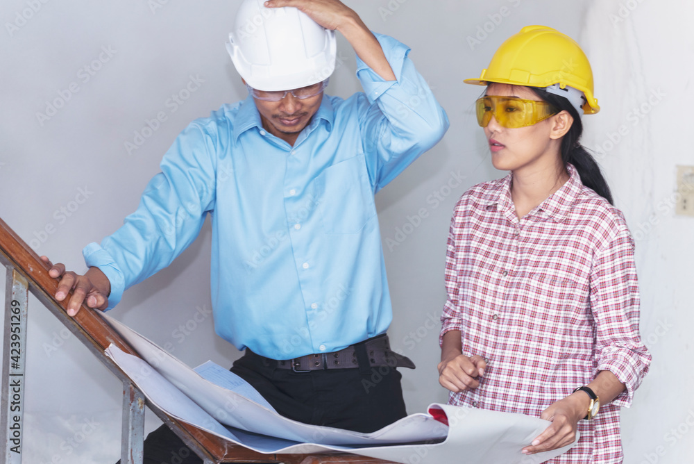 Fototapeta premium Construction engineer teamwork Safety Suit Trust Team Holding White Yellow Safety hard hat Security Equipment on Construction Site. Hardhat Protect Head for Civil Construction Engineer Concept
