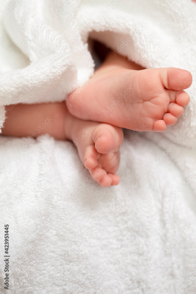 Infants and Newborns Concepts. Macro Closeup Shoot of a Four Week Old Baby Boy Feet Over White Towel. Infants and Newborns Concepts. Macro Closeup Shoot of a Four Week Old Baby Boy Feet Over White Towel.