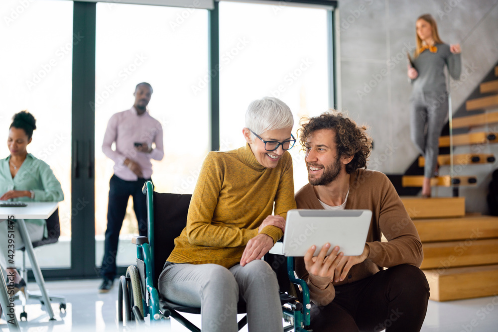 Working in inclusion office. Senior business woman with disabiliy in wheelchair. Working in inclusion office. Senior business woman with disabiliy in wheelchair.