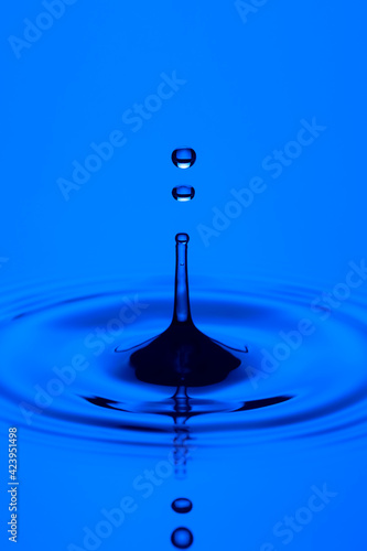 Macro Shot of Abstract Blue Water Splashes or Rain Drops Levitating Over Serene Water Surface.
