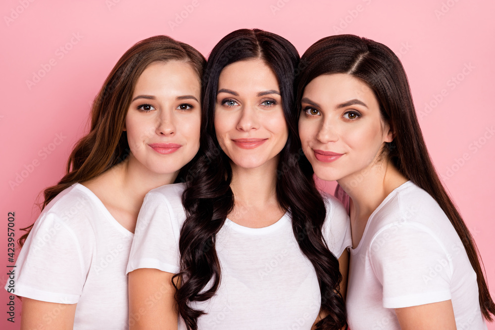 Photo of three charming young girls happy positive smile family friends isolated over pink color background Photo of three charming young girls happy positive smile family friends isolated over pink color background