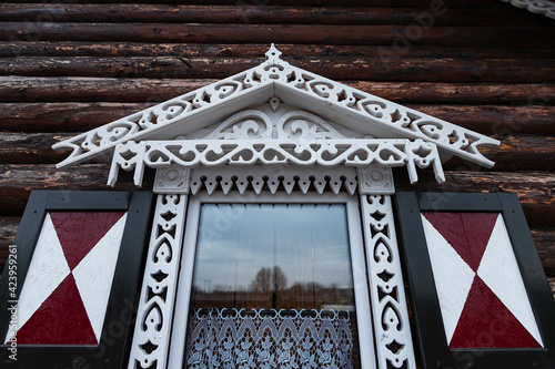 carved platbands on the windows. decorative decoration with wooden ornaments of window shutters. country house in a traditional style photo