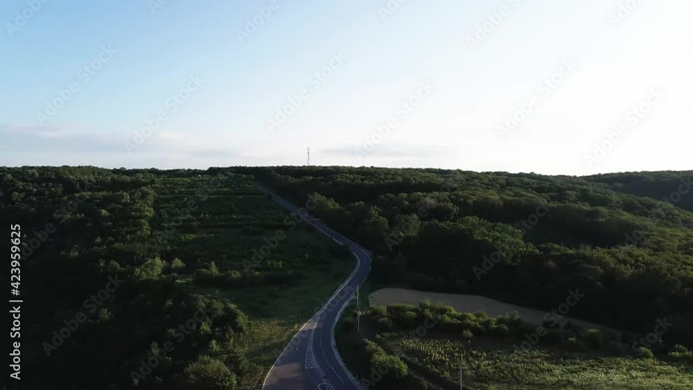 The modern road that crosses through a forest. Video filmed with a 4k drone. The forests of Moldova seen from above