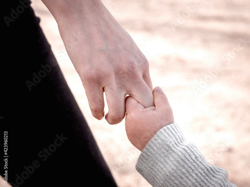 Mum and child holding hands.