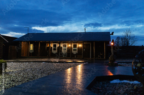 night view of the wooden hut. country house in a traditional style. the warm light from the windows reflects on the ice