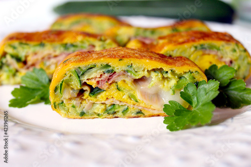 Omelet rolls with zucchini, ham and cheese. Top view with copy space. Healthy breakfast.