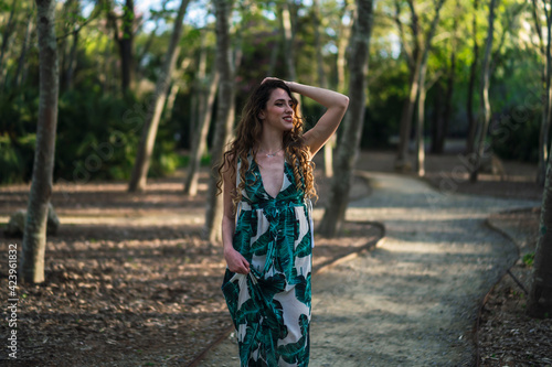 Chica guapa joven dando un paseo y tomándose fotos en un parque verde en primavera