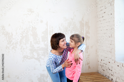 Woman in plaid shirt embracing her daughter