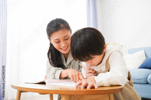 家でお母さんと一緒に勉強をする男の子 © maroke
