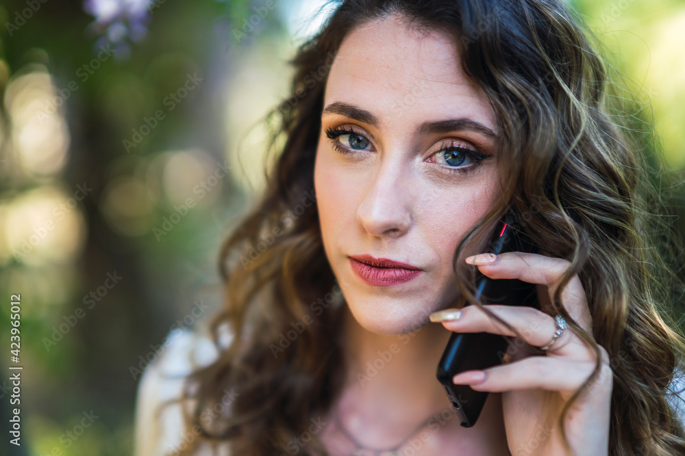 Chica joven guapa en un parque usando el smartphone y dando un paseo en primavera Chica joven guapa en un parque usando el smartphone y dando un paseo en primavera