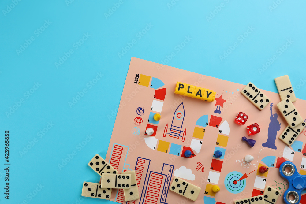 Components of board games on light blue background, flat lay. Space for text - obrazy, fototapety, plakaty 