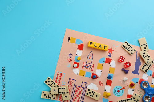 Components of board games on light blue background, flat lay. Space for text photo