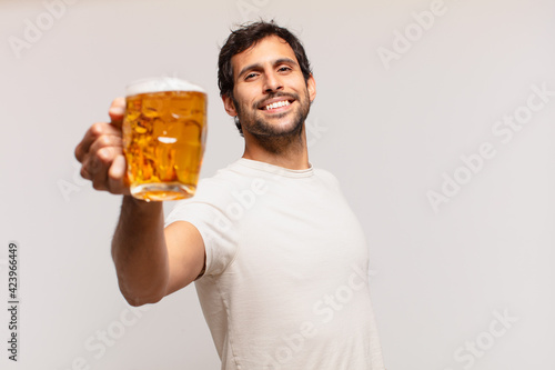 Foto young handsome indian man happy expression and holding a beer