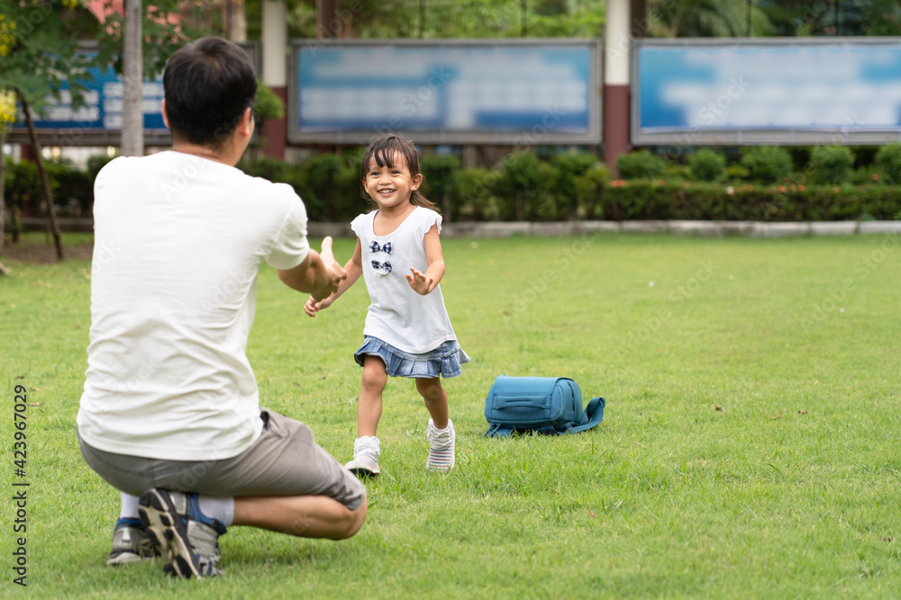Asian father is waiting to hug the daughter's to pick up to home with happy moment after the school time, concept of parent care, education and back to school for student. Asian father is waiting to hug the daughter's to pick up to home with happy moment after the school time, concept of parent care, education and back to school for student.
