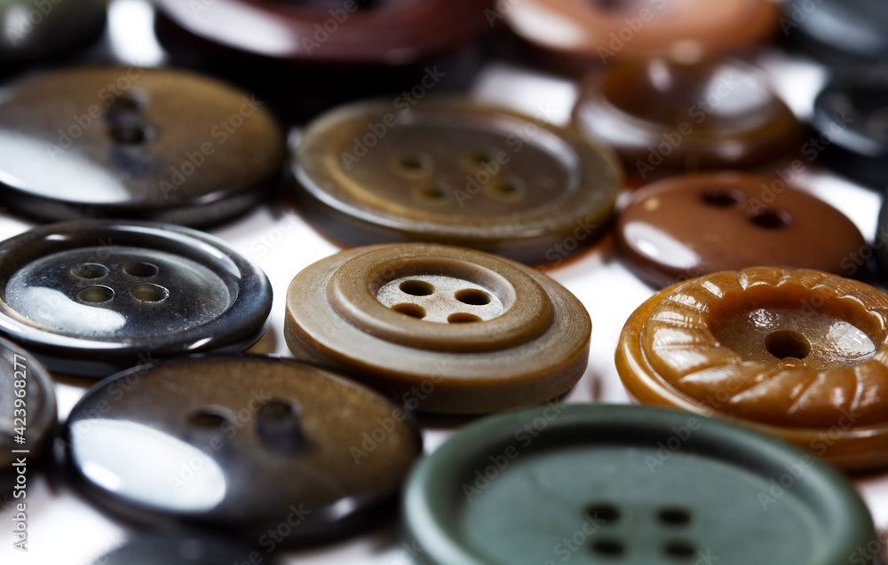 Colorful bright brown, beige and ochre buttons background. Old vintage buttons close-up. Copy space. side view. Background of buttons in natural shades . Flat lay. Colorful bright brown, beige and ochre buttons background. Old vintage buttons close-up. Copy space. side view. Background of buttons in natural shades . Flat lay.
