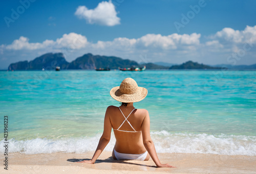 Portrait of a sensual young female in white bikini enjoying warm tropical ocean water. © GVS
