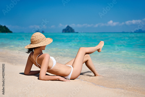 Portrait of a sensual young female in white bikini enjoying warm tropical ocean water.