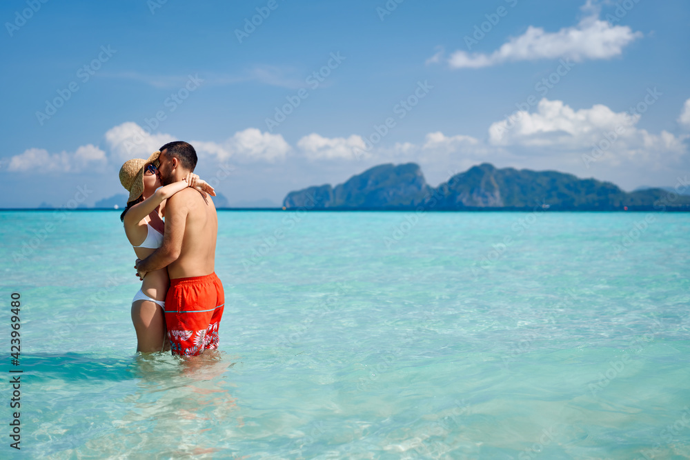 Romantic couple kissing on paradise tropical beach with copy space