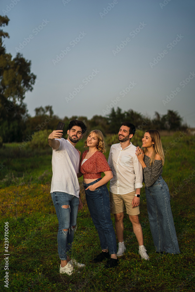 Grupo de amigos disfrutando de zona verde en primavera tomando selfies Grupo de amigos disfrutando de zona verde en primavera tomando selfies