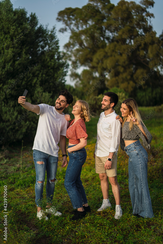Grupo de amigos disfrutando de zona verde en primavera tomando selfies Grupo de amigos disfrutando de zona verde en primavera tomando selfies