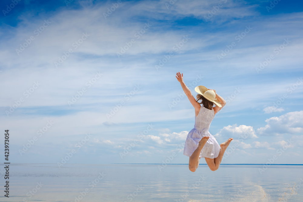 happy young woman jumping on the beach happy young woman jumping on the beach
