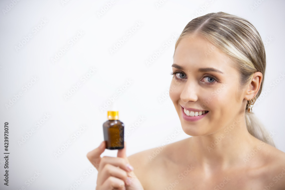 Close up beauty portrait of a beautiful half naked woman applying face cream and looking away isolated over white background Close up beauty portrait of a beautiful half naked woman applying face cream and looking away isolated over white background