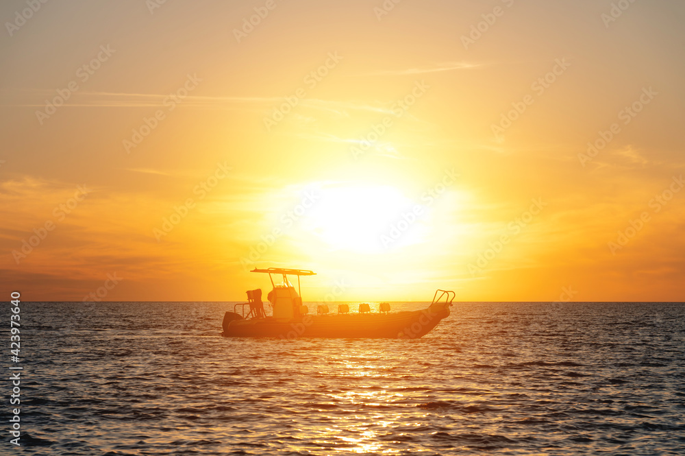 Unidentified tourist boat without people in the sea at sunset