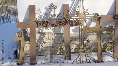 Big metal cross standing on the side of the wall of the church on a sunny day photo