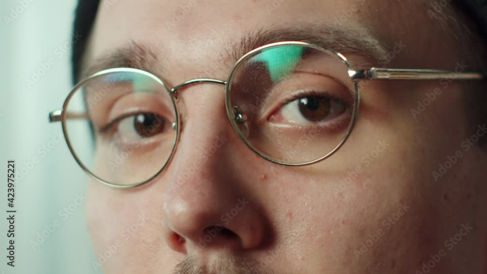 Close-up face of young man with mustache, taking off glasses, hat. Headshot of funny hippster. Looking at the camera. Portrait of brown-eyed serious student. Close-up face of young man with mustache, taking off glasses, hat. Headshot of funny hippster. Looking at the camera. Portrait of brown-eyed serious student.