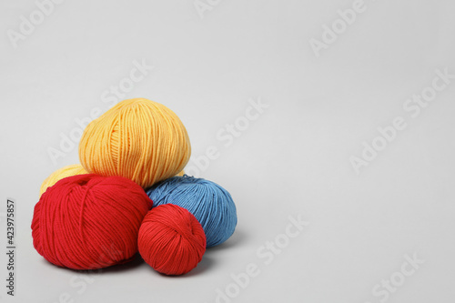 Soft woolen yarns on white background, space for text