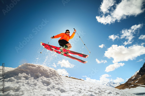 young caucasian guy jumping from a springboard on skis