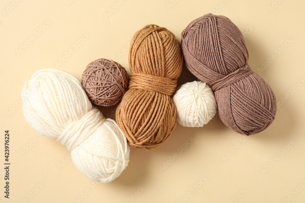 Colorful woolen yarns on beige background, flat lay Colorful woolen yarns on beige background, flat lay