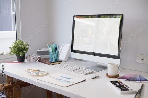 Working space of artist with computer  canvas  coffee cup  book and office supplies in home office room. clipping path