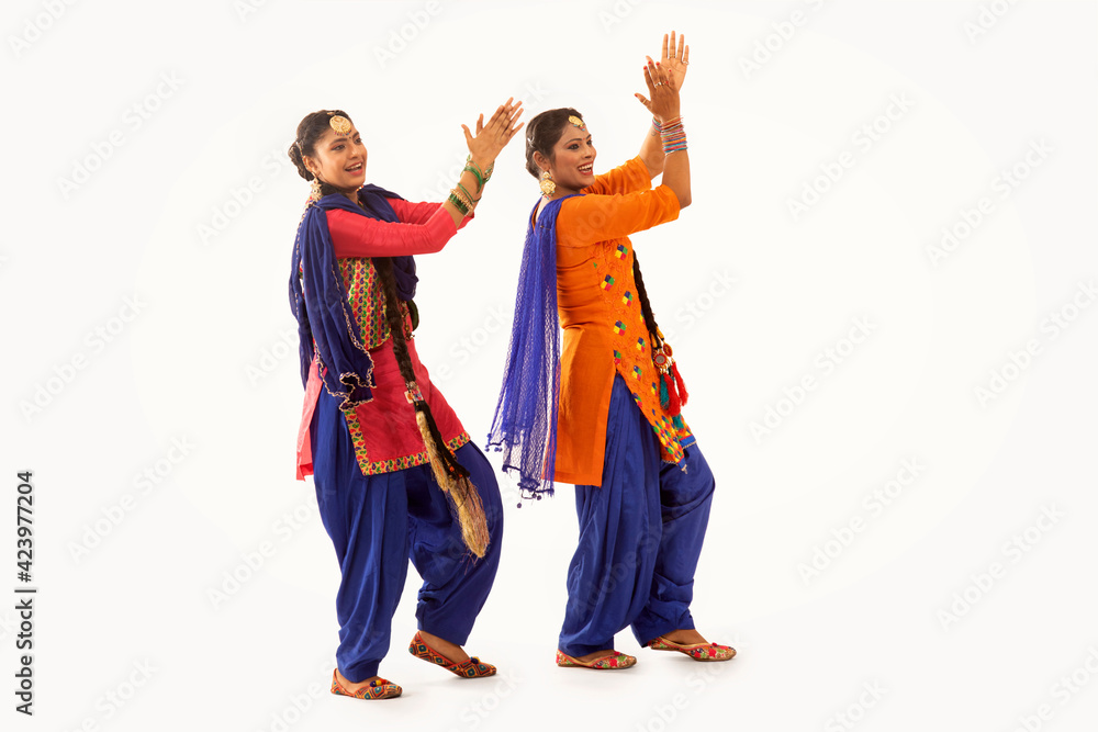 Fototapeta premium Two Giddha Dancers performing a dance step together. 