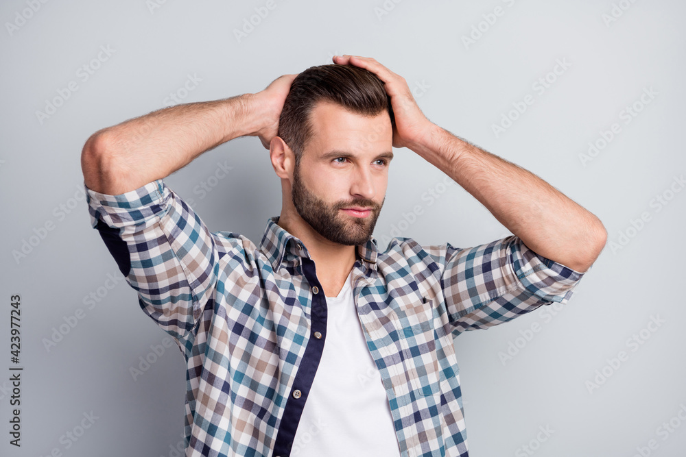 Photo portrait of confident curious man looking empty space touching hairdo in barber shop isolated on grey color background Photo portrait of confident curious man looking empty space touching hairdo in barber shop isolated on grey color background