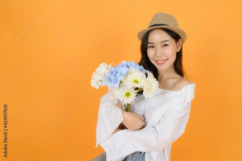 Portrait of pretty cute young asian girl with casual white shirt and jeans feeling excited, on orange background