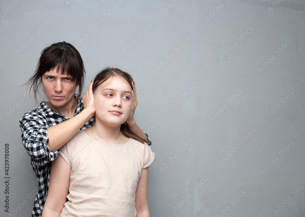 Distraught 30s mother closing her child's ears Distraught 30s mother closing her child's ears