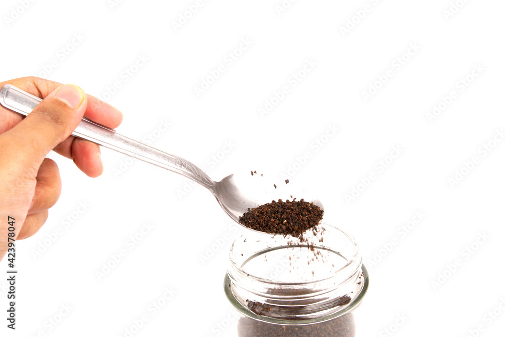 A hand hold a spoon with a blended and dried tea leaf isolated on white background A hand hold a spoon with a blended and dried tea leaf isolated on white background