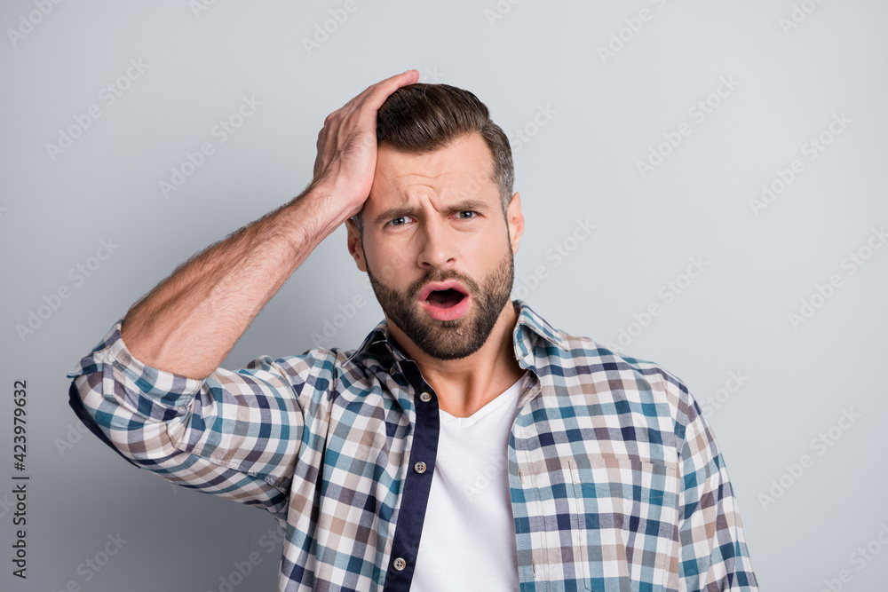 Photo of young handsome shocked unhappy stressed man made a mistake hold hand head isolated on grey color background Photo of young handsome shocked unhappy stressed man made a mistake hold hand head isolated on grey color background